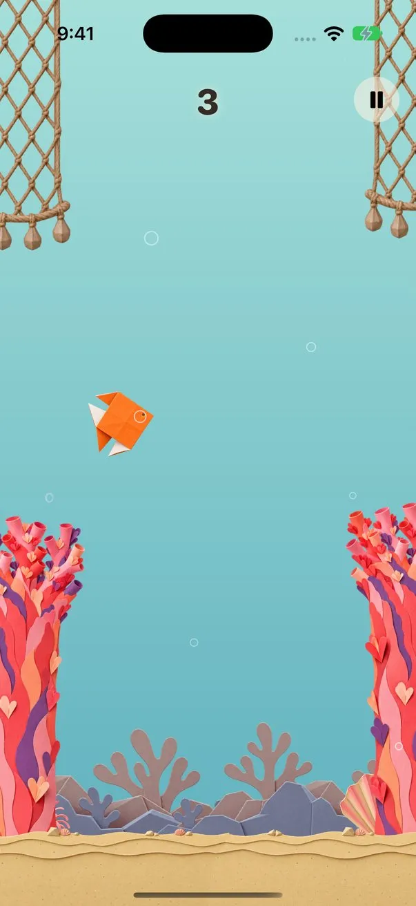 Coral Reef: an orange origami fish swims between hanging rope nets and pink paper coral, over a sandy sea floor.