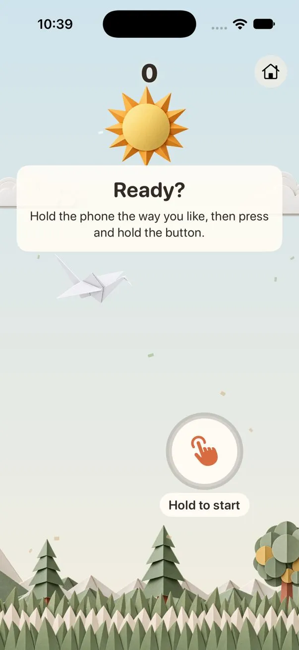 Tilt Glide ready screen on iPhone: the text Ready? Hold the phone the way you like, then press and hold the button. A round Hold to start button and a paper crane.